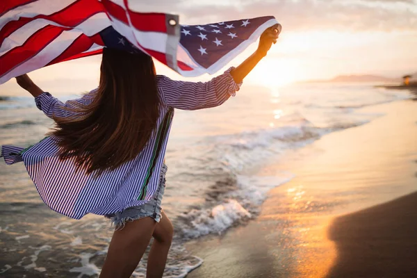 在美国庆祝独立日和享受自由的同时 快乐的女人微笑着在海滩上奔跑 — 图库照片