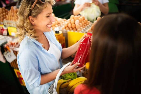 Young happy woman shopping healthy food on the market
