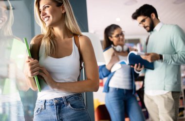 Mutlu genç üniversite öğrencileri birlikte okuyorlar. Üniversitede bir grup çok ırklı insan