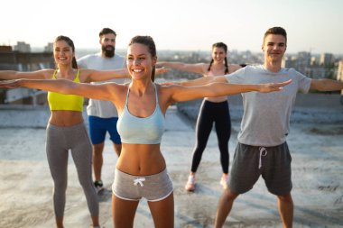 Bir grup zinde insan çatıda antrenman yapıyor.