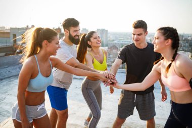 Bir grup zinde insan çatıda antrenman yapıyor.