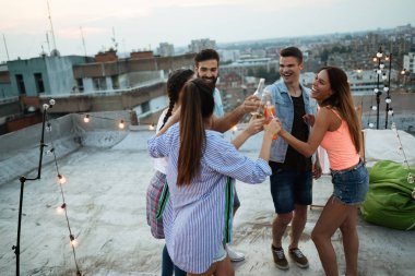 Mutlu arkadaşlar çatıda parti veriyorlar. Eğlence, yaz, şehir yaşam tarzı ve arkadaşlık kavramı