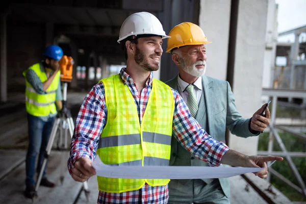 Tryggt team av arkitekter och ingenjörer som arbetar tillsammans på byggarbetsplatsen — Stockfoto