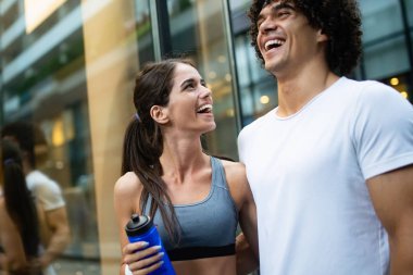 Fitness, spor, arkadaşlık ve yaşam tarzı kavramı-gülümseyen çift jogging açık