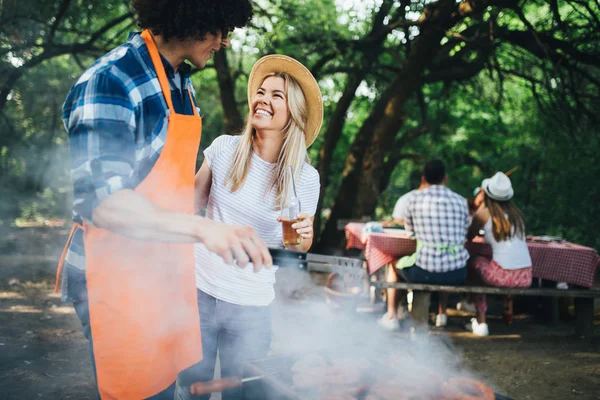 Friends having a barbecue party in nature while having fun