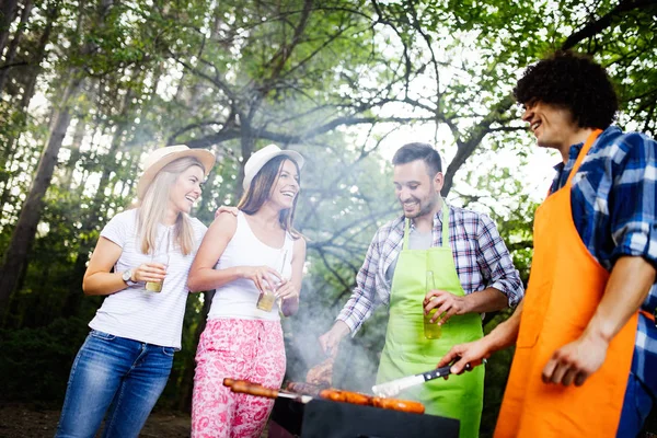 Friends having a barbecue party in nature while having fun