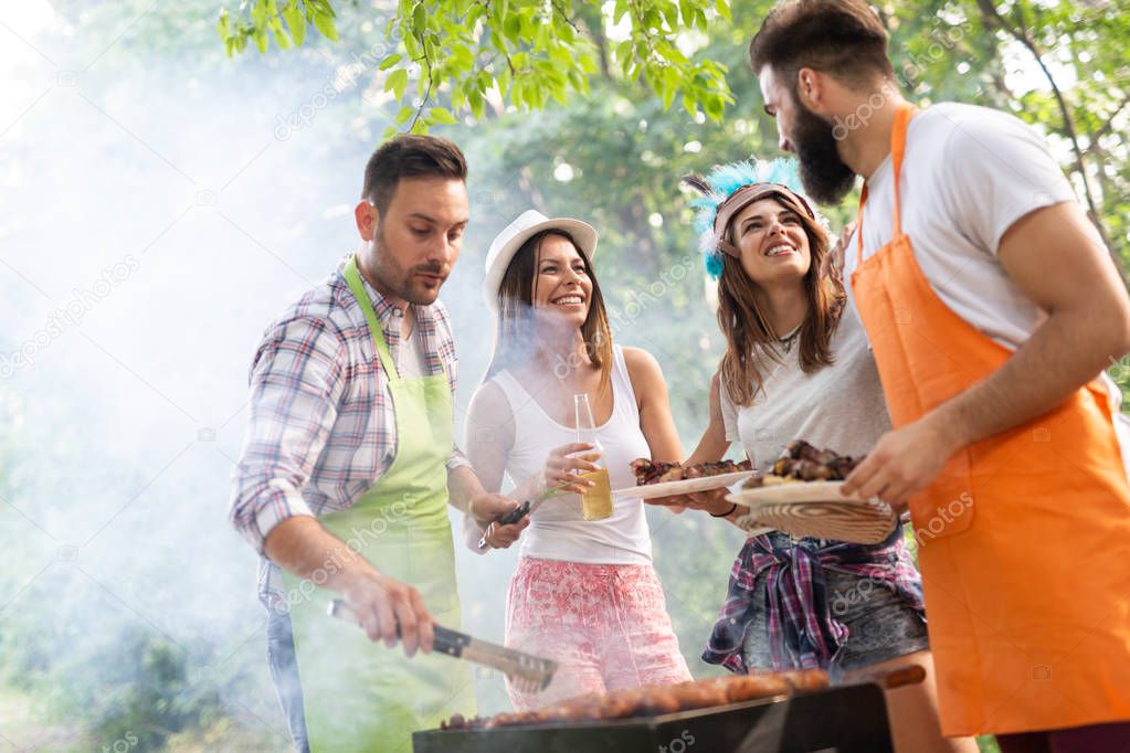 Friends having a barbecue party in nature while having fun