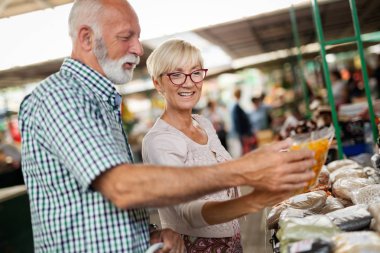 Gülümseyen kıdemli çift satın alma sebze ve meyve merket