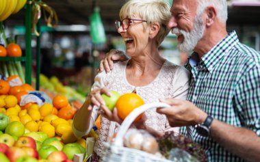 Gülümseyen kıdemli çift satın alma sebze ve meyve merket