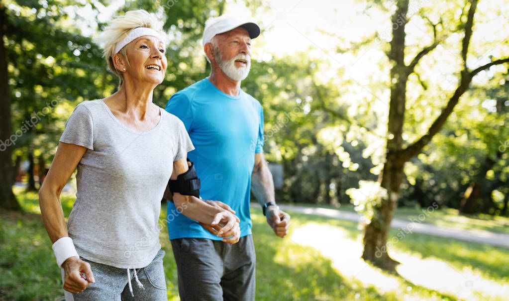 Happy senior people jogging to stay helathy and lose weight
