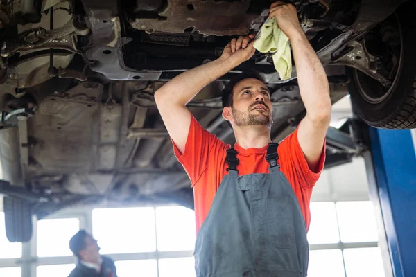 Zwei Hübsche Mechaniker Uniform Arbeiten Autoservice Mit Angehobenem Fahrzeug — Stockfoto