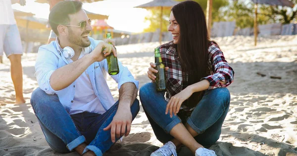 Feliz Pareja Joven Bebiendo Cerveza Divirtiéndose Playa Atardecer —  Fotos de Stock