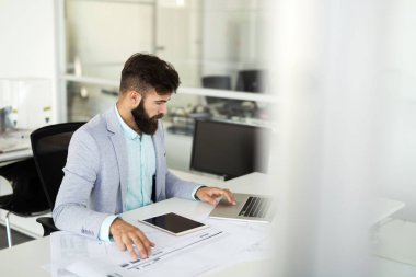 Yakışıklı işadamı modern ofis içinde laptop üzerinde çalışıyor