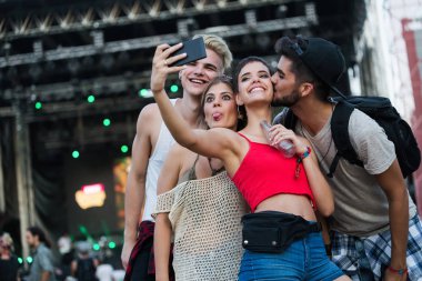 Mutlu genç arkadaşlar müzik festivalinde eğleniyor.