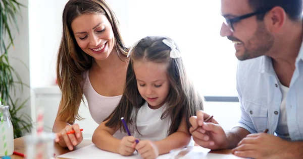 Mom and dad drawing with their beautiful daughter