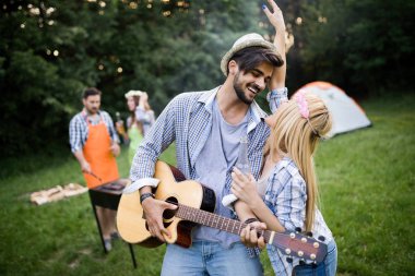 Doğada açık havada birlikte barbekü yapan bir grup arkadaş