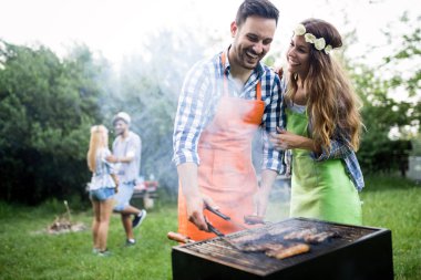 Doğada açık havada birlikte barbekü yapan bir grup arkadaş
