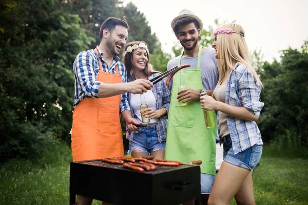 Friends making a barbecue together outdoors in the nature