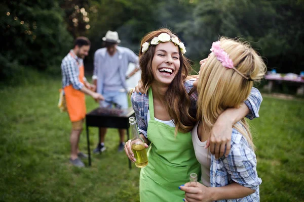 Friends having a barbecue party in nature while having fun