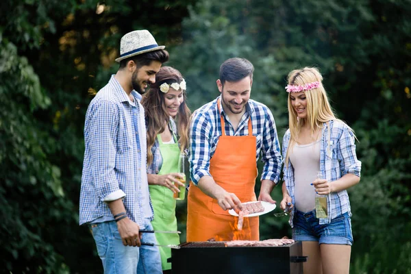 Group of friends having barbecue party in forest