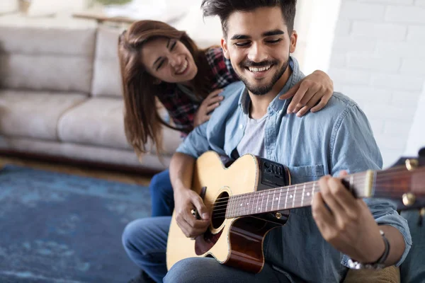 Jovem Homem Bonito Tocando Guitarra Para Sua Bela Namorada — Fotografia de Stock