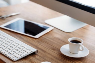 Ofis masası bilgisayar, tablet ve fincan kahve ve diğer aksesuarlar