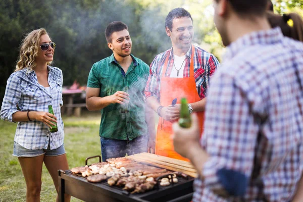 Νέοι Απολαμβάνουν Barbecuing Εξωτερική — Φωτογραφία Αρχείου