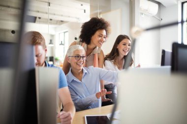 Modern bilişim şirketinde işbirliği yapan programcılar uygulama geliştiriyor