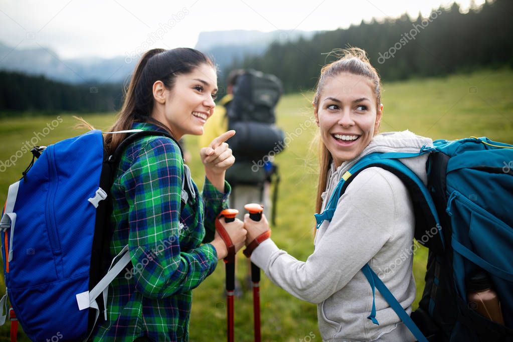 Adventure, travel, tourism, hike and people concept - group of smiling friends hiking