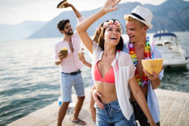 Genç ve eğlenceli insanlar sahilde yazın tadını çıkarıyor.