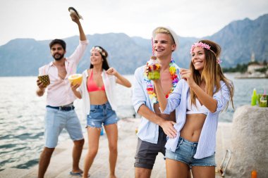 Genç ve eğlenceli insanlar sahilde yazın tadını çıkarıyor.