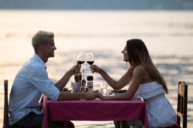 Mutlu genç çift yaz akşamında romantik bir akşam yemeği yiyor.