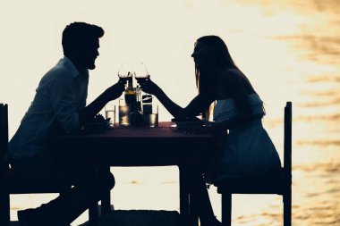 Tropikal tatil akşam yemeği sırasında tost genç romantik çift