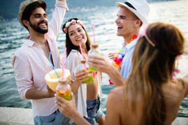 Bir grup mutlu arkadaş sahilde eğleniyor ve eğleniyorlar.