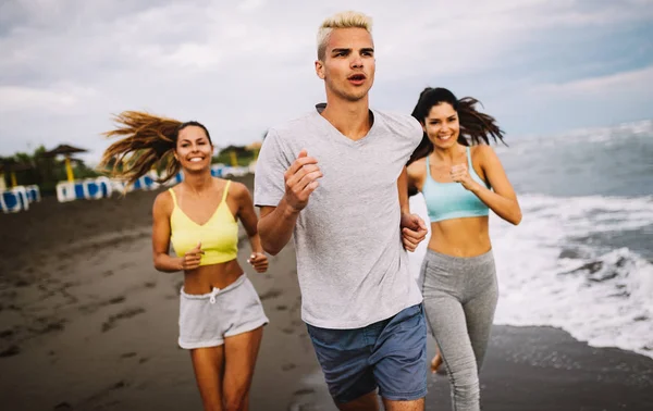 Group of sport people jogging on the beach