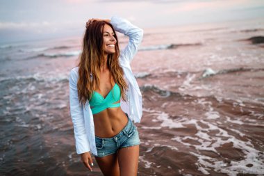 Yaz tatilinde gün batımındaki güzel seksi kadın.