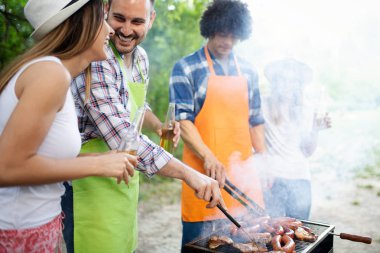 Doğada barbekü ve ızgara partisi olan mutlu arkadaşlar