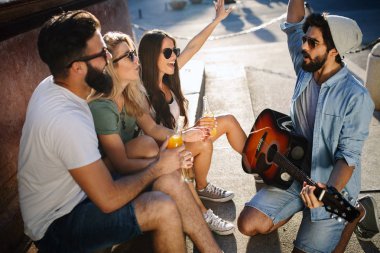 Gülümseyen, konuşan ve birlikte eğlenen bir grup genç arkadaş
