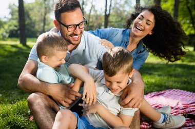 Mutlu çoklu nesil aile parkta piknik yapıyor.