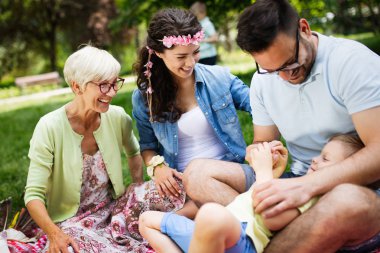 Mutlu çoklu nesil aile parkta piknik yapıyor.