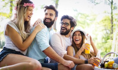 Güneşli bir günde piknik yapıyor parkta mutlu arkadaş grubu.