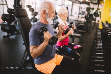 Olgun erkek ve kadın spor salonunda egzersizleri yapıyor sağlıklı kalmak için uygun