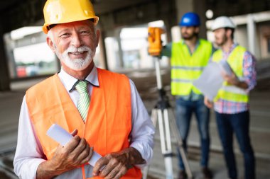İnşaat mühendisi mimar ustabaşıyla inşaat alanını kontrol ediyor.