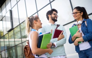 Mutlu genç üniversite öğrencileri birlikte okuyorlar. Üniversitede bir grup çok ırklı insan