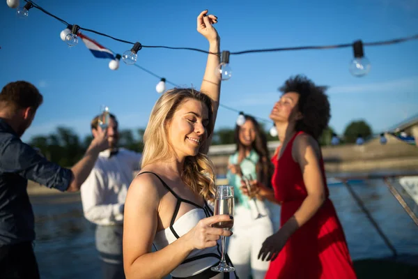 Group of happy friends at party dancing and smiling together