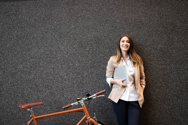 Happy business woman with bicycle to work on urban street in city. Transport and healthy lifestyle concept