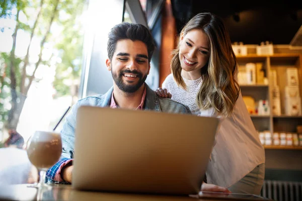 Genç çift ya da üniversite öğrencisi kullanarak dizüstü bilgisayar Notebook birlikte kahve dükkanı veya üniversite kampüsü çalışma