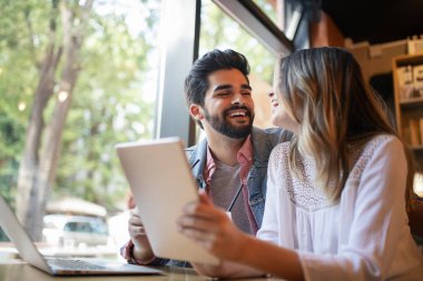 Genç çift ya da üniversite öğrencisi kullanarak dizüstü bilgisayar Notebook birlikte kahve dükkanı veya üniversite kampüsü çalışma