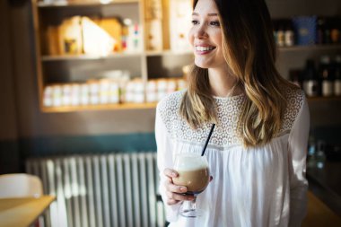 Güzel gülümseyen kadın kafede veya iş yerinde kahve içme