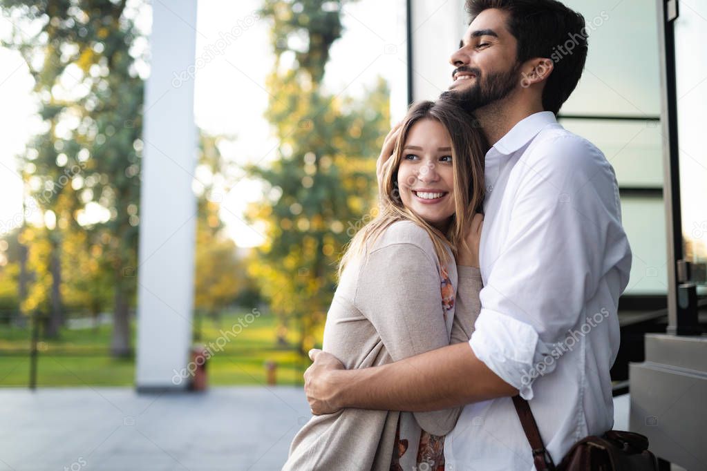 Happy young couple hugging and laughing in love outdoors